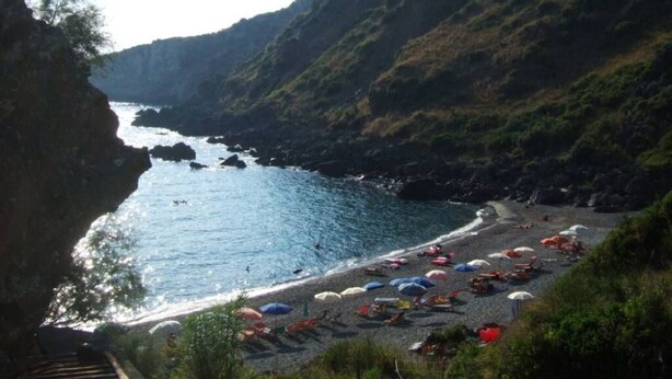 A coastal beach with umbrellas and chairs, surrounded by cliffs. - Typical dwelling with garden & sea view on the Bay  (Scalea)