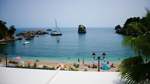 A beach with boats, a rocky outcrop, and umbrellas. - Bianco Resort - Adults Only (Parga)