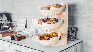 A buffet setup with bread, pastries, and French fries on a wooden board. - Bianco Resort - Adults Only (Parga)