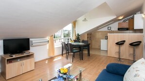 A modern apartment with a dining area, kitchen, and living room. - Apartment Lala (Dubrovnik)