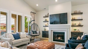 Una sala de estar moderna con chimenea, asientos cómodos y televisor.
