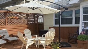 En terrasse med udendørs møbler, et bord og en plantekasse med blomster.
