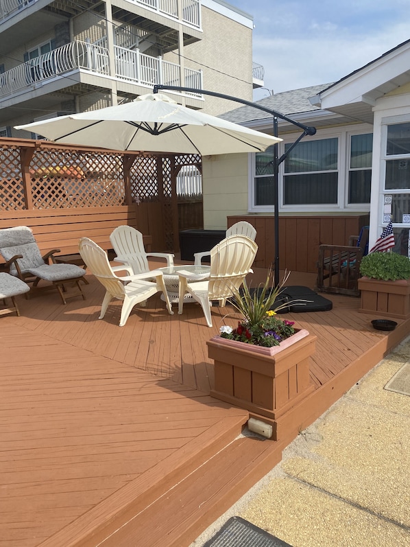 A patio with outdoor furniture, a table, and a planter with flowers.