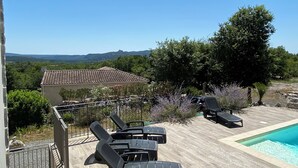 A poolside area with lounge chairs, a small pool, and a view of the surrounding landscape. - Villa 135m2 private swimming pool (open from May to September) (Labeaume)