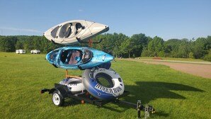 A kayak and a canoe on a trailer with a grassy field and trees in the background. - Piece of Paradise / Private Hot Tub (Holcombe)