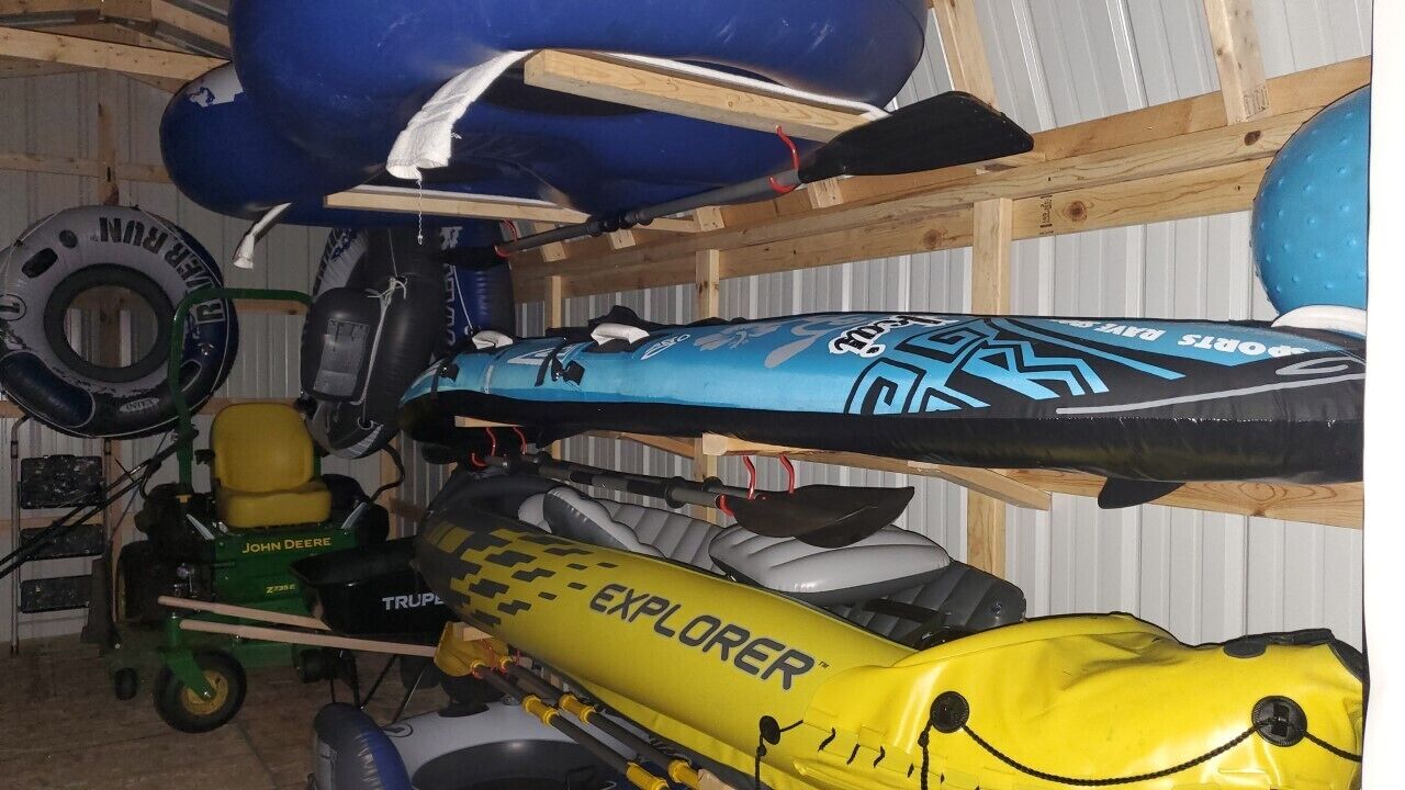 A storage area with kayaks and a lawnmower.
