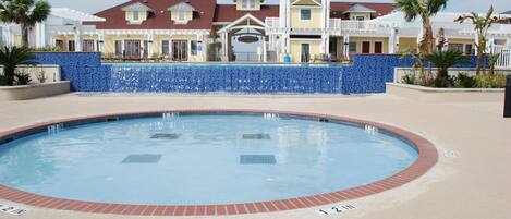 A swimming pool with a no diving sign, surrounded by a blue-tiled wall and a brick border.