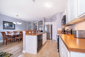Enjoy meals in the spacious kitchen with a central island, stainless steel appliances, and a dining table for four.
