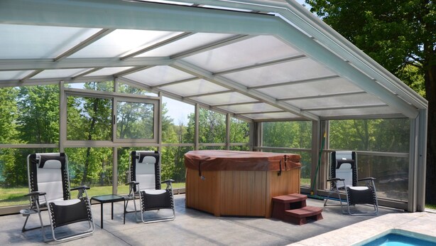 A covered outdoor area with a hot tub, seating, and a pool. - UNIQUE! 40 Pvt. Ac. Fireplace, Grill, Enclosed Heated Pool & Hot Tub (Saugerties)