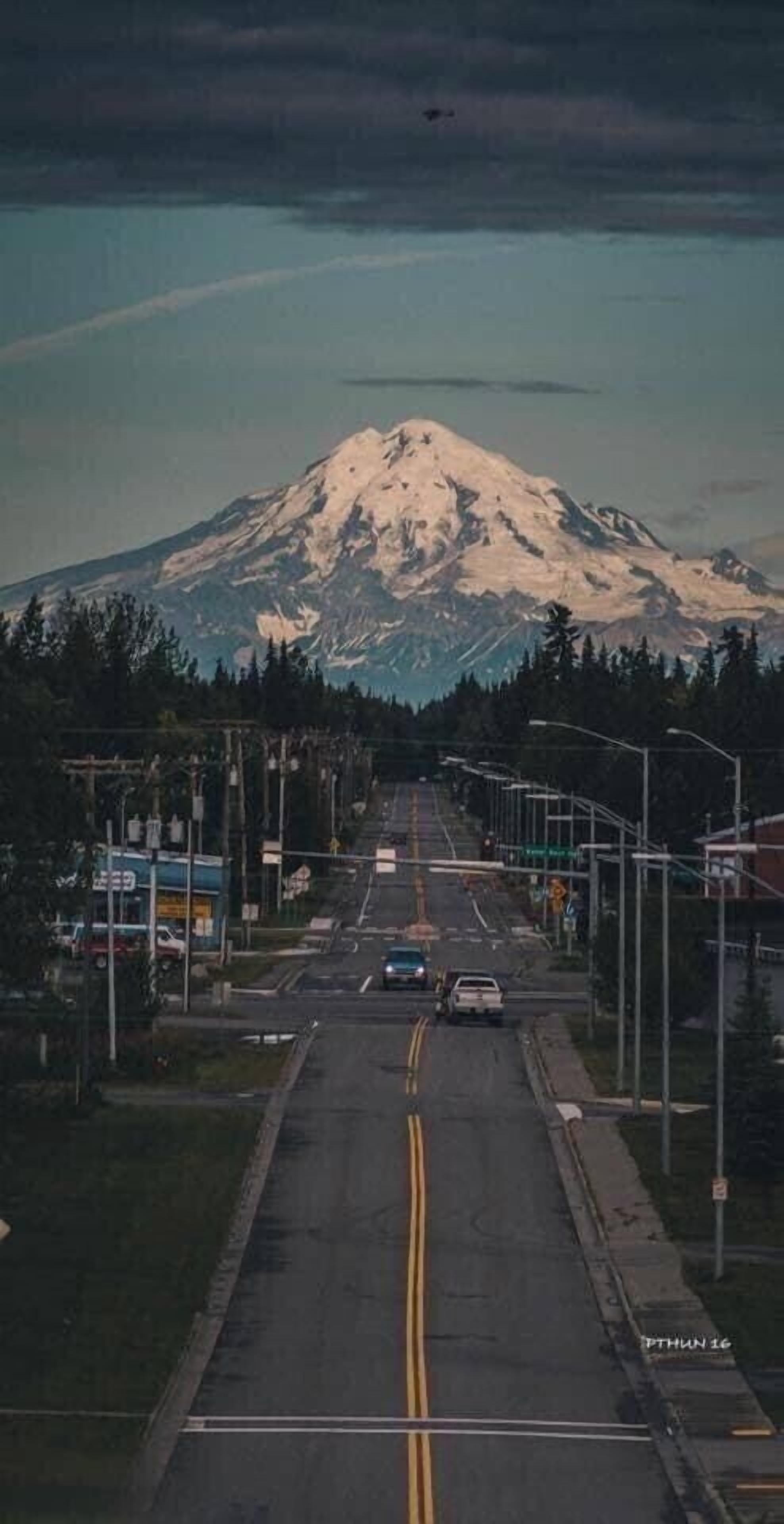 A road leading to a mountain with a snow-capped peak.