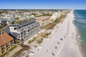 A beachfront hotel with multiple balconies, a sandy beach, and ocean views. - Crystal Clear - Beach Front Property with Private Pool Area, Rooftop Deck & Theater (Destin)