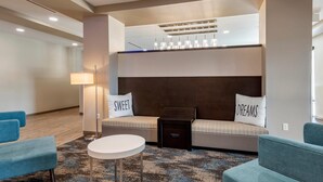 A modern hotel lobby with a sofa set, a round table, and a lamp. - MainStay Suites Durango (Durango)