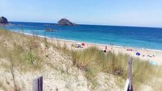 A beach with clear blue water, a sandy shore, and a small rocky island in the distance. - Les Cottages du golf 2/3 (LE TRONCHET)