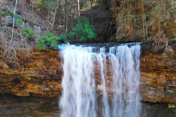 Een waterval stort neer over een rotswand.