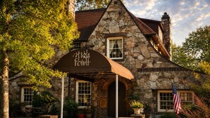 A stone building with a sign reading 'High Point' and an American flag. - The Woods at The Retreat at Deer Lick Falls (Monteagle)