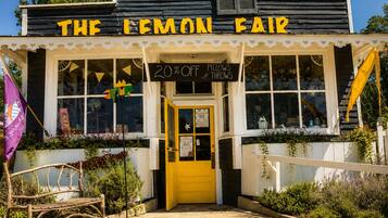Um edifício com uma placa que diz 'THE LEMON FAIR' e uma porta amarela.