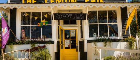 A building with a sign reading 'THE LEMON FAIR' and a yellow door.