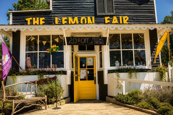 Un edificio con un letrero que dice 'THE LEMON FAIR' y una puerta amarilla.