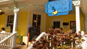 A yellow building with a blue sign reading 'Stirling's Coffee House' and a signboard listing daily specials. - The Woods at The Retreat at Deer Lick Falls (Monteagle)