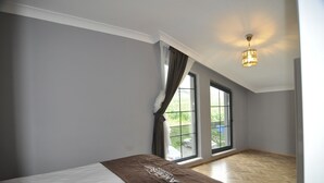 A bedroom with a bed, large windows, and a chandelier. - Anemo Suite (Çaykara)