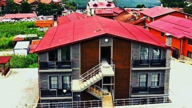 A multi-story building with a red roof and a staircase leading to the entrance. - Anemo Suite (Çaykara)