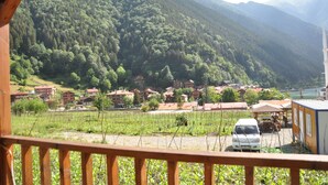 A view of a mountainous area with a village, a white van, and a small building. - Anemo Suite (Çaykara)