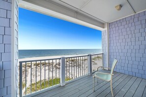 Eine überdachte Veranda mit Blick auf Strand und Meer.