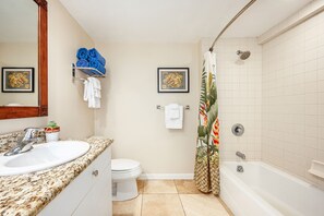 A bathroom with a sink, toilet, and bathtub. There are towels and a shower curtain. - Islander Family Studio 137, Ground Floor, Steps to Pool and Beach (Kapaa)