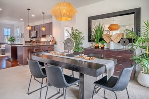Una cocina moderna con armarios de madera oscura, una isla central e iluminación colgante.