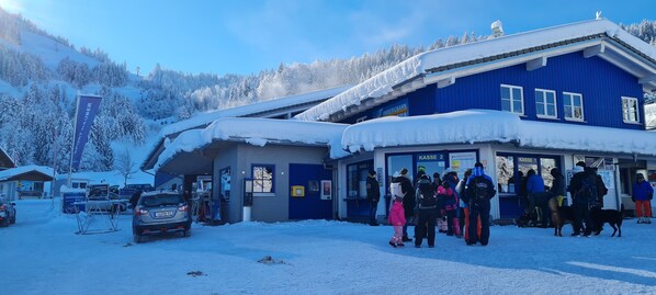 A blue building with a sign reading "KASSE 2" and "KASSE 1" indicating ticket counters.