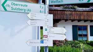 Un poste de señalización direccional con indicaciones de varias rutas y un mapa.
