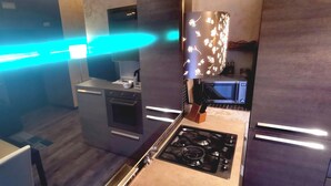 Una cocina moderna con estufa a gas, microondas y muebles oscuros.