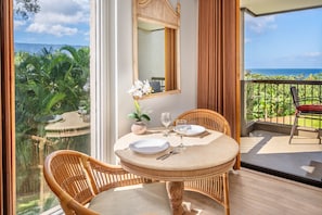 Enjoy a romantic dinner for two in this inviting dining area with a view of lush greenery and the distant mountains.