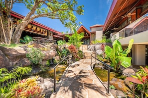 Stroll through the tranquil courtyard, surrounded by lush tropical plants and a serene pond.