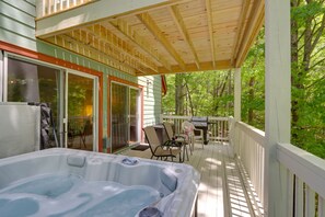 A wooden deck with a hot tub, outdoor furniture, and a view of the forest. - Blue Ridge Getaway w/ Hot Tub & Seasonal View! (Blue Ridge)