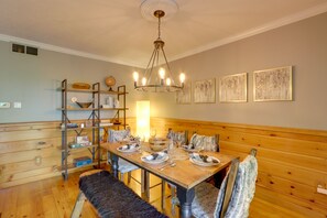A dining area with a wooden table set for four, a bench, and a chandelier. - Blue Ridge Getaway w/ Hot Tub & Seasonal View! (Blue Ridge)