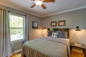 A bedroom with a bed, a ceiling fan, a window with curtains, and two wall-mounted lamps. - Blue Ridge Getaway w/ Hot Tub & Seasonal View! (Blue Ridge)