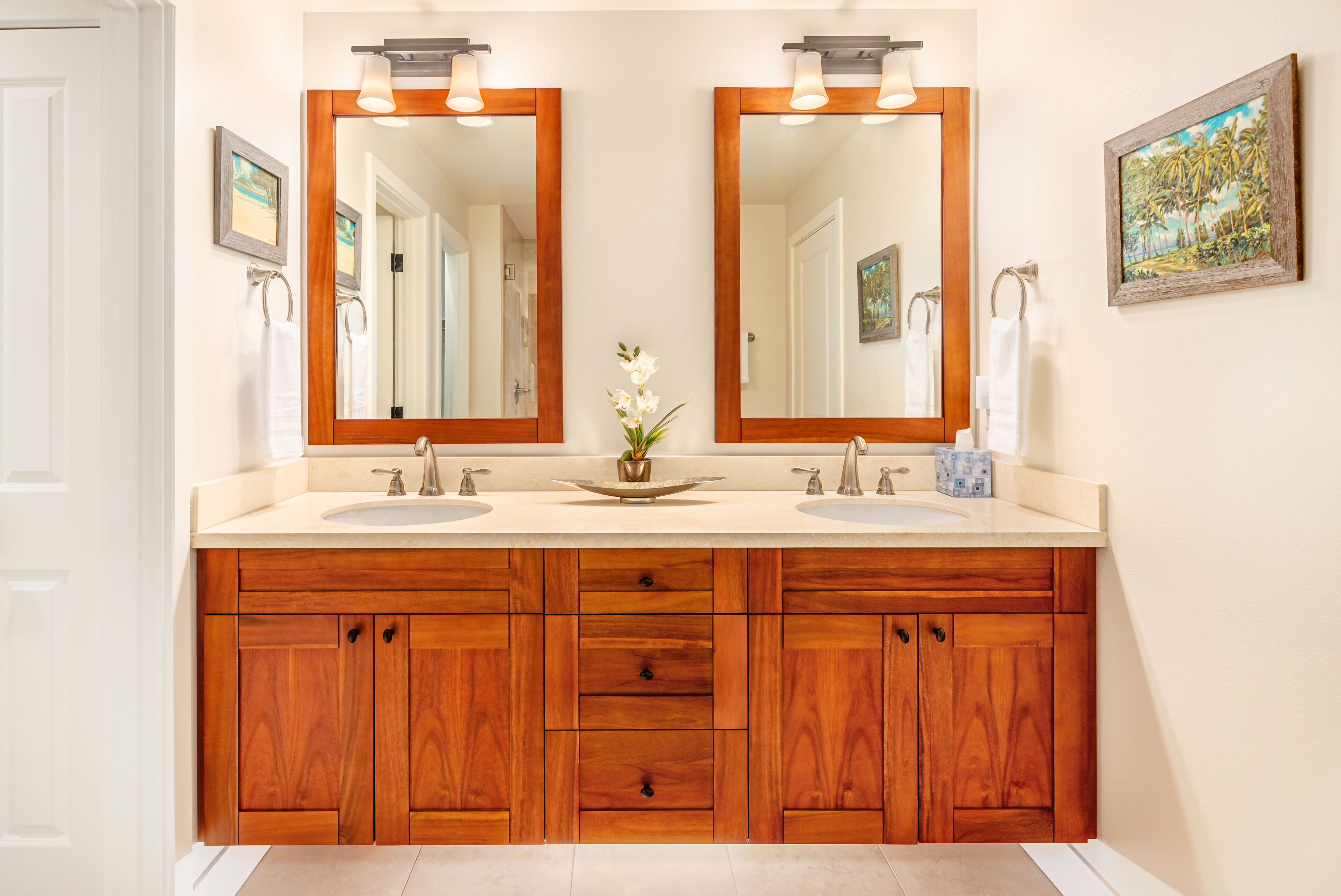 Un baño con tocador de madera, dos lavamanos y un espejo grande.