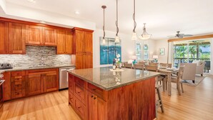 A spacious kitchen with wooden cabinets, a granite countertop, and a large island. - Pili Mai Family Condo 5C, 3 Bedroom 3 Bath, Mountain View, Cool Lanai, (Koloa)