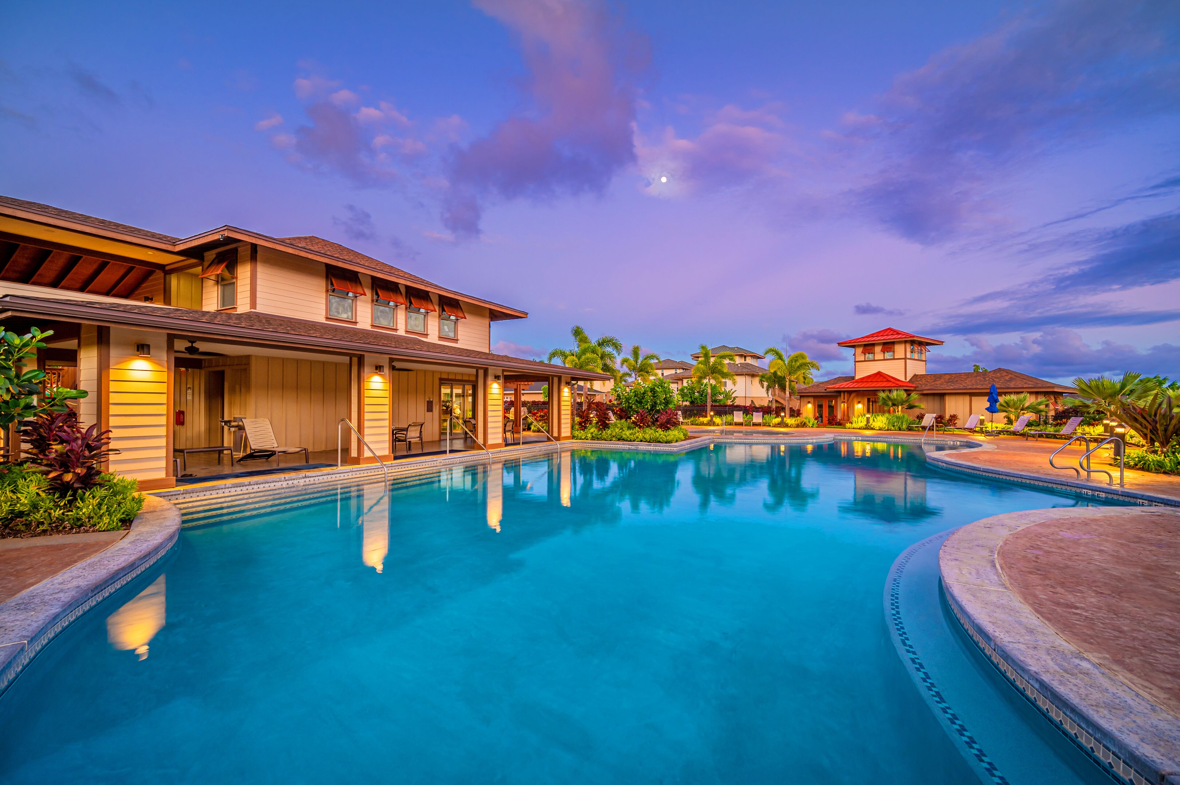 Un resort con una gran piscina, varias construcciones y palmeras.