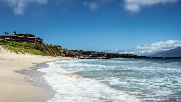 A beachfront property with a large building overlooking the ocean.