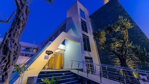 Un hôtel moderne doté d’une architecture originale, avec un escalier imposant et un grand arbre en premier plan.