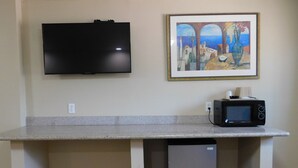 Une kitchenette équipée d’un téléviseur à écran plat, d’un four à micro-ondes et d’un petit réfrigérateur.