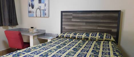 Una habitación de hotel con una cama, un escritorio y una silla.