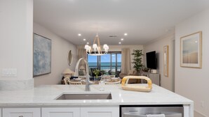 Una cocina moderna con una isla central, electrodomésticos integrados y vistas al exterior.