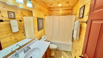 A wooden cabin bathroom with a sink, toilet, and bathtub.