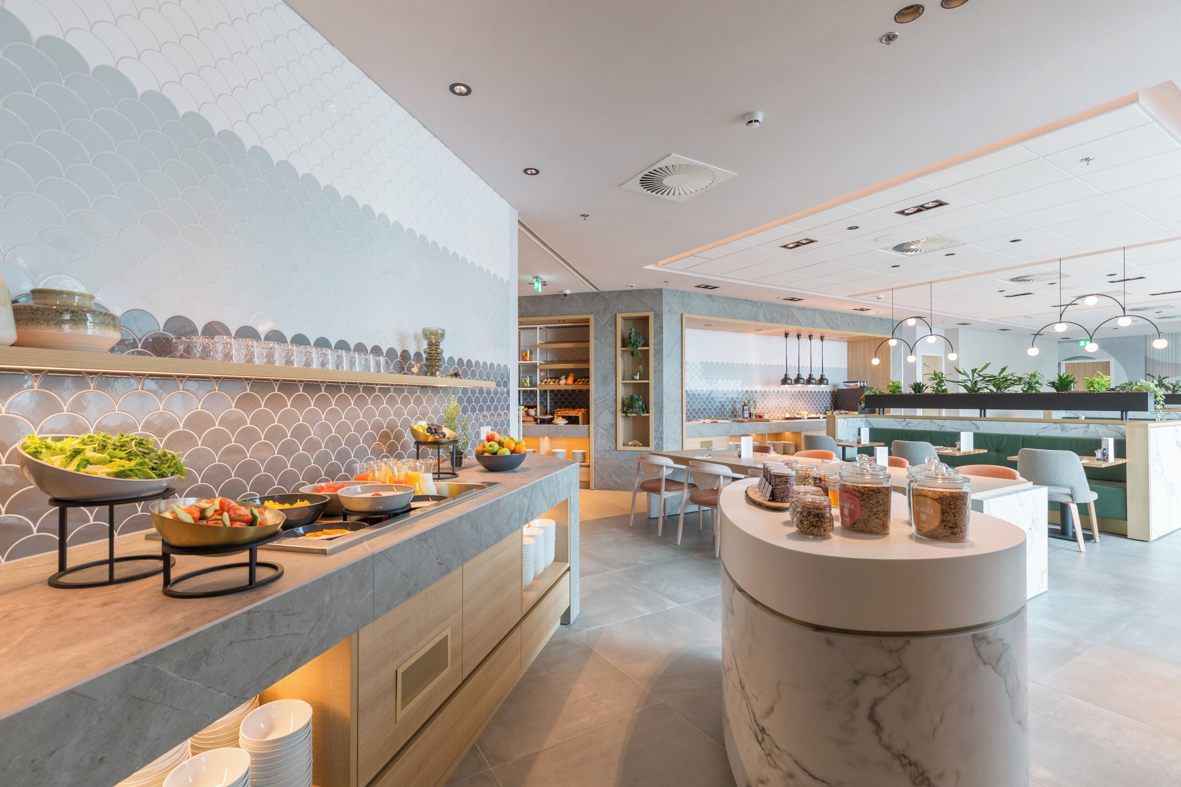 A modern kitchen with a marble countertop, built-in shelves, and a variety of food items.