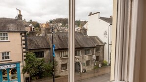 Une vue d’une ville avec des bâtiments, dont un magasin dont l’enseigne indique « Ongles ».