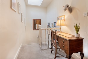 Una habitación con escritorio, silla, lámpara y un trofeo de caza.