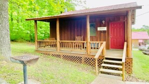 A wooden cabin with a porch, a red door, and a sign that reads "LIBERTY". - Liberty Cabin Number 301 (Mountain View)
